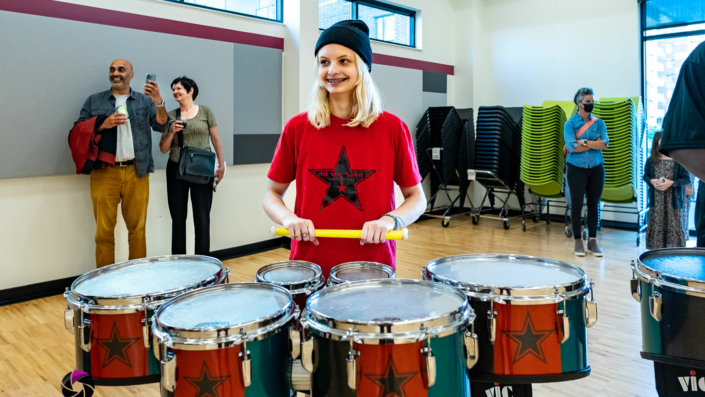 Black Star Drum League player posing with drums at the Madison Youth Arts center