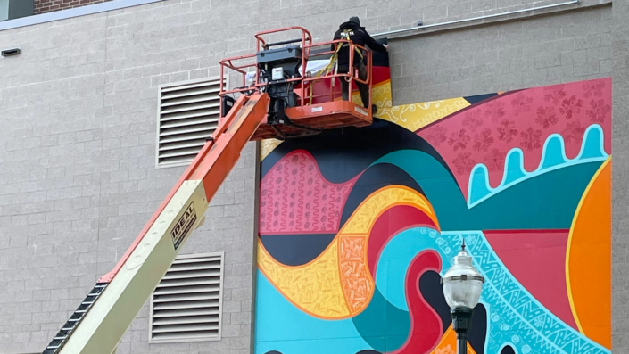 Mural being put up for display at the Madison Youth Arts center