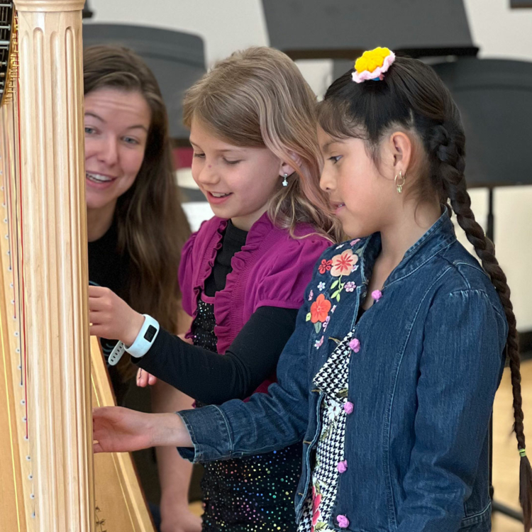 Kids examining a harp at the Madison Youth Arts center