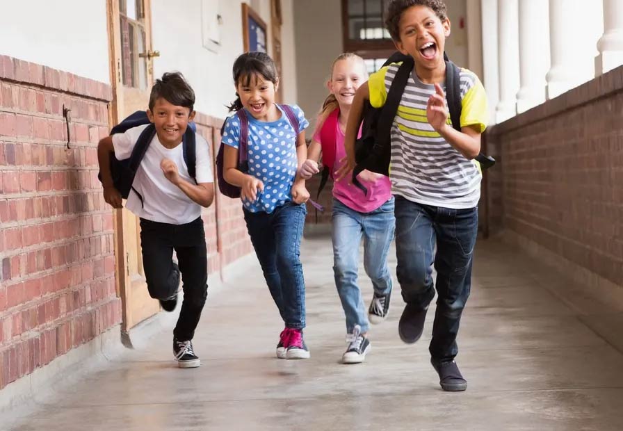 Kids running excitedly down a hallway